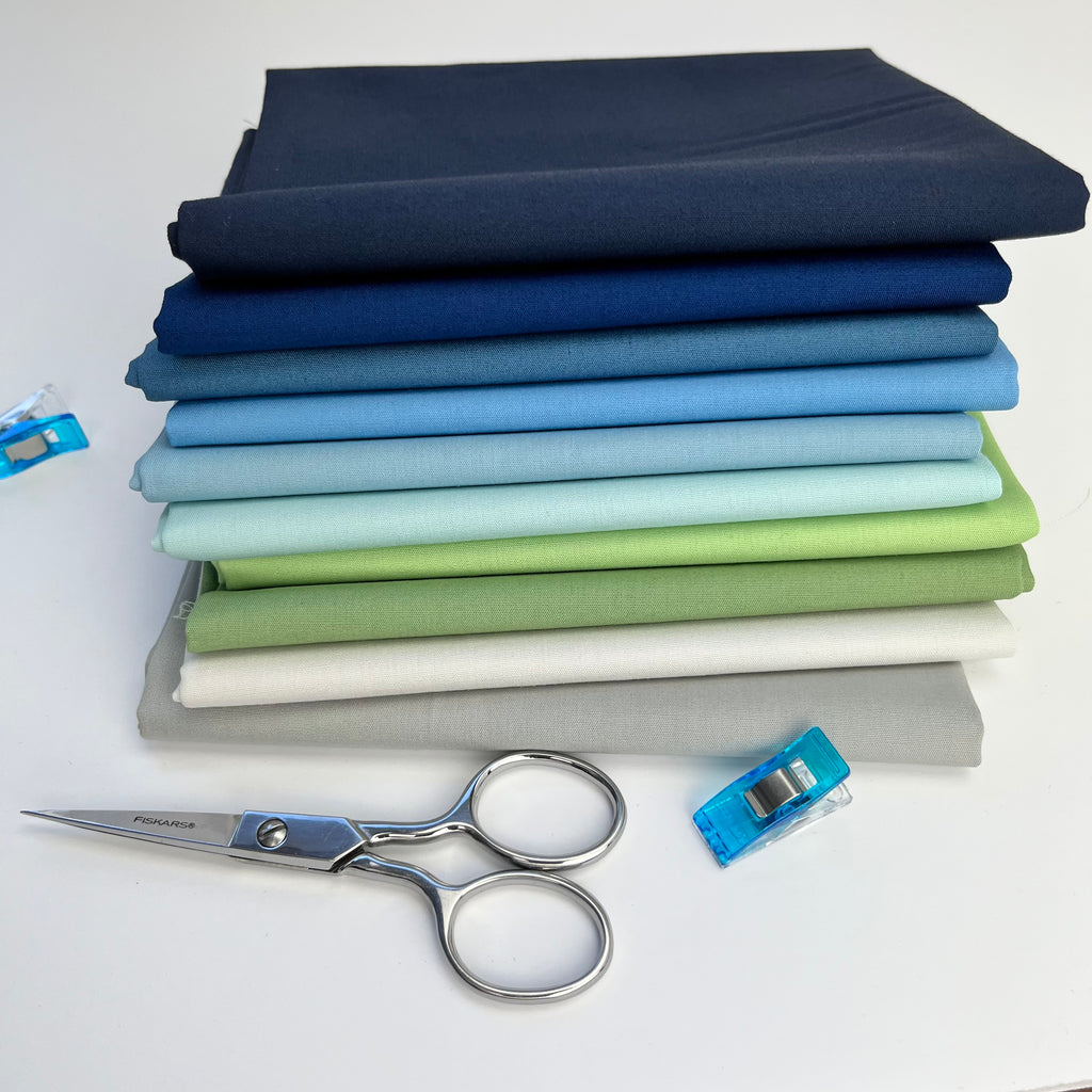 Stack of shoreline fabrics in navy, blue, green and gray