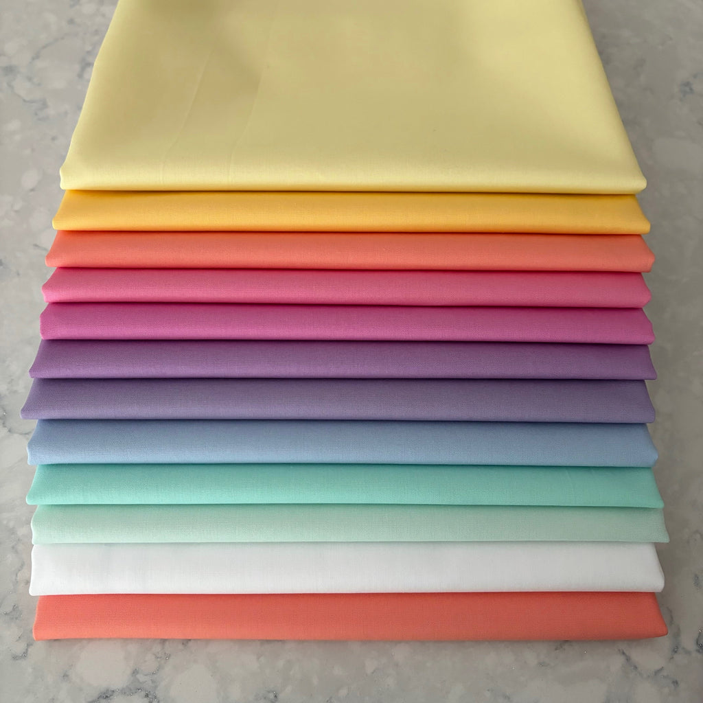 Stack of rainbow colored pastel fabrics